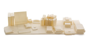 Precise three-dimensional paper reconstruction of a workspace by Herbert Stattler, showing desk objects as monochromatic white paper models based on original pencil drawings.
